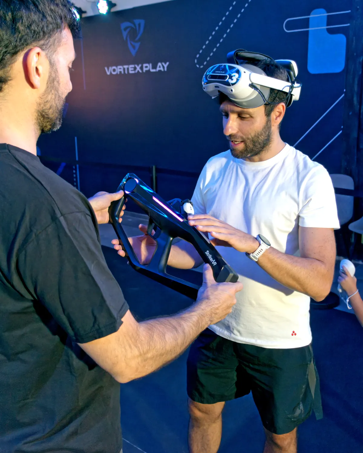 An operator hands a gun and a headset to a player.